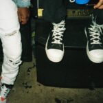 person wearing black and white converse all star high top sneakers